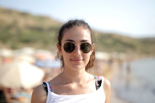 头发海滩上一位戴眼镜的女性的选择性聚焦镜头健康女性漂亮