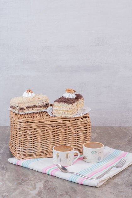 液体两片蛋糕和咖啡放在桌布上甜点篮子桌布
