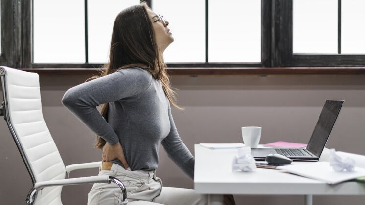 预防在家工作时背痛的女人工作保护冠状病毒