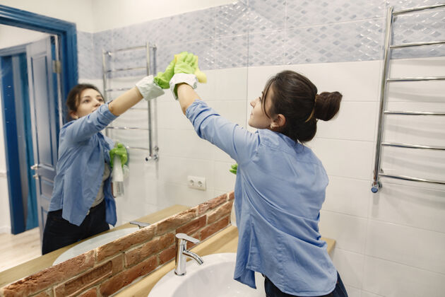 成人在家工作的家庭主妇穿蓝色衬衫的女人在浴室的女人卫生抛光女性