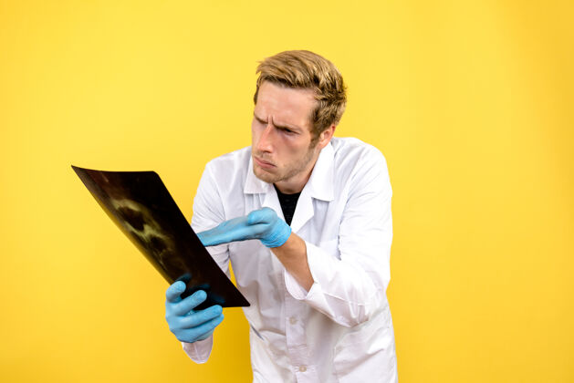 Covid正面图男性医生拿着黄色背景的x光片手术医疗卫生商人帅哥秘书