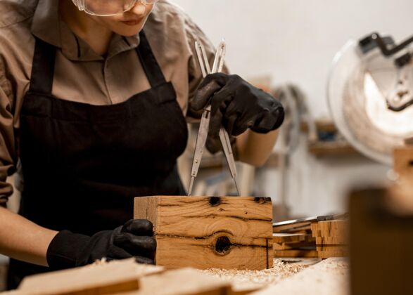 劳动办公室里的女木匠正在测量一块木头妇女技能工作