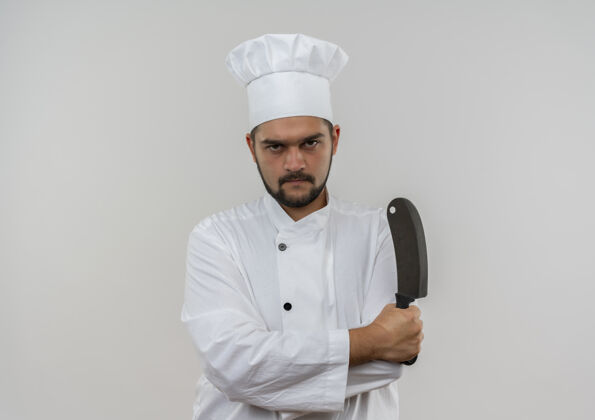 未出租穿着厨师制服的年轻男性厨师站在那里 姿势紧闭 拿着菜刀孤立地站在空白处男性制服复制