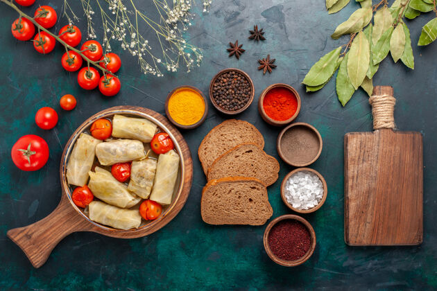 烹饪俯瞰图美味的肉食卷心菜内卷面包和新鲜西红柿在深蓝色的桌子上早餐书桌一餐