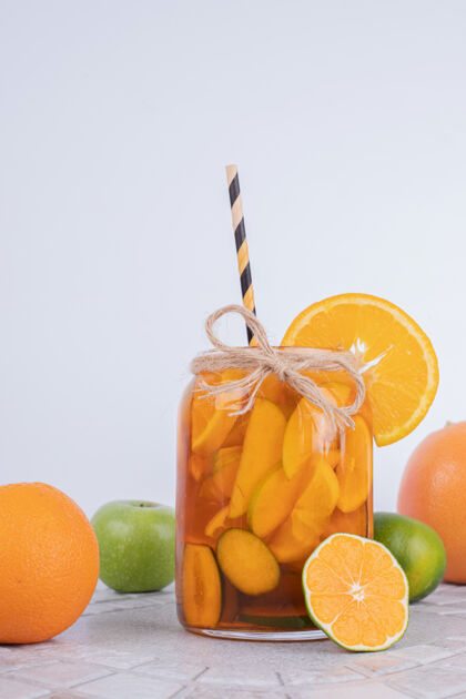 玻璃杯一杯白墙上有水果片和新鲜水果的果汁提神成熟果汁