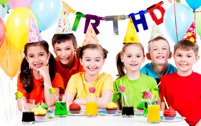 饮料一群穿着五颜六色衬衫的快乐的孩子在生日聚会上玩得很开心-被隔离在白色的地板上桌子六乐趣