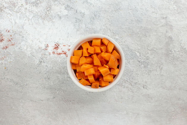 维生素俯视图切碎的橙色蔬菜在白色背景上的小锅里背景锅健康