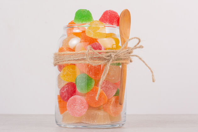 糖果五颜六色的果酱放在玻璃罐里 用木勺舀着甜点勺子零食
