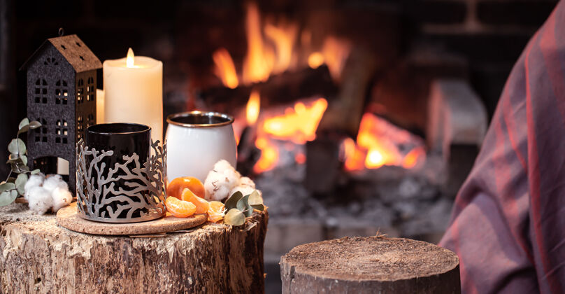 乡村舒适的组成与一个杯子 蜡烛和一个燃烧的壁炉复制空间橘子杯子火休息