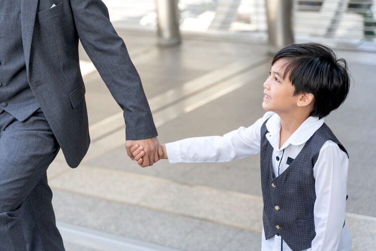 夫妇儿子牵着爸爸的手在市区商业区手男孩亚洲人家庭