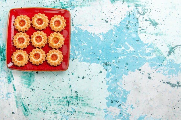 拼图顶视图甜饼与橙色果酱内红色盘子蓝色背景里面表面甜