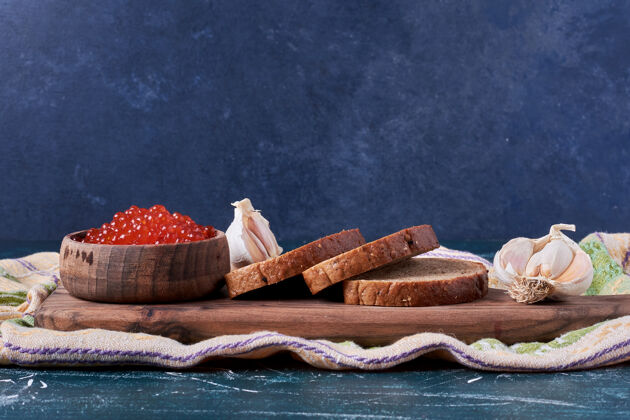 产品木板上的红鱼子酱和面包片杯子膳食质量
