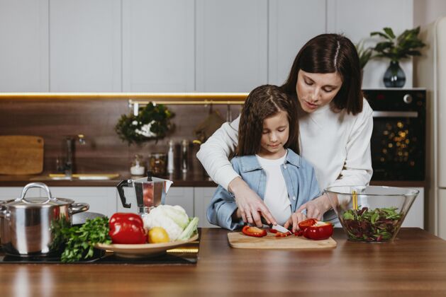 女儿母亲和女孩在厨房准备食物的前视图女人厨房家庭