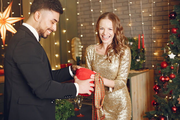 欢乐穿圣诞装饰品的人穿黑色西装的男人穿红色盒子的女人女人女人男人