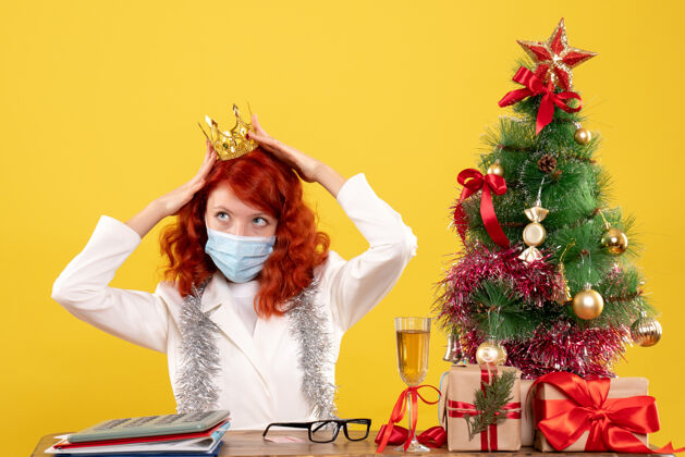 皇冠前视图：戴着面具的女医生在圣诞礼物上戴着黄色的皇冠坐着面具头发