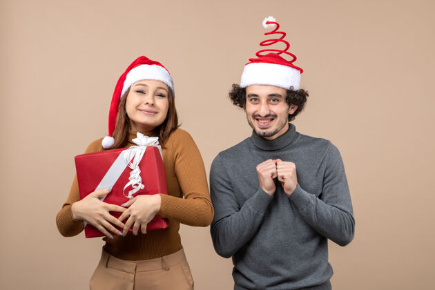 帽子新年心情与有趣可爱的情侣戴着红色圣诞老人帽的灰色照片大人男人男人