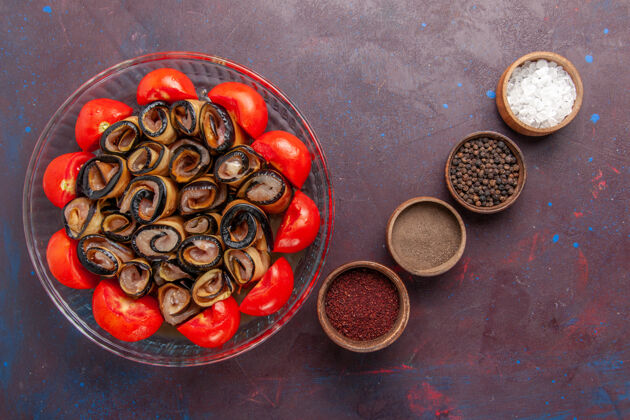 杯子俯视图蔬菜餐切片和卷西红柿与茄子和调味品在黑暗的背景饮料豆类餐
