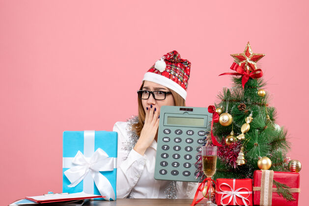 礼物女工手持计算器围着粉色礼物的正视图键盘乐器礼物盒子