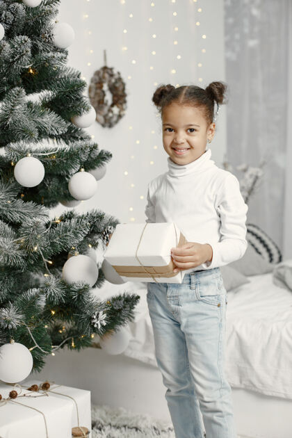 童年穿白色毛衣的孩子站在圣诞树旁的女儿节日盒子传统