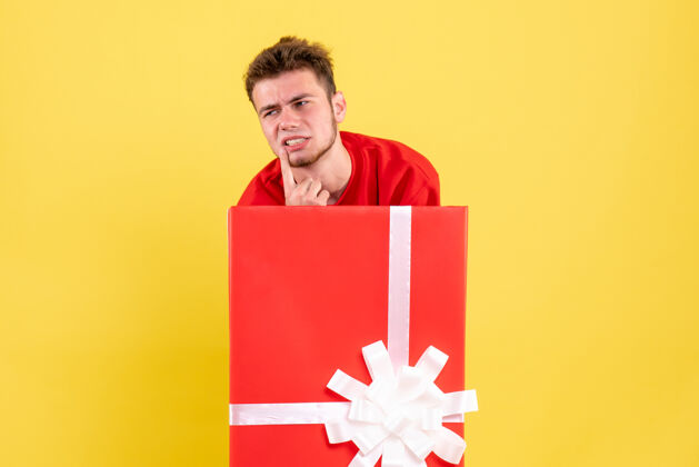 衬衫正面图穿红衬衫的年轻男子站在礼品盒内年年轻男性圣诞节