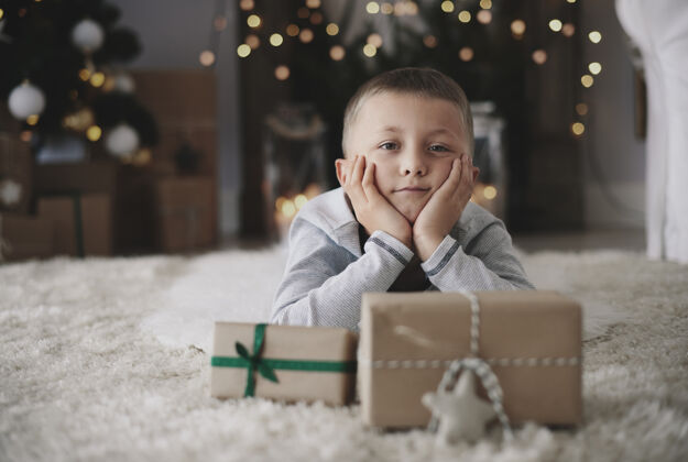 礼物手抱头躺在地板上做梦的男孩地毯圣诞节手