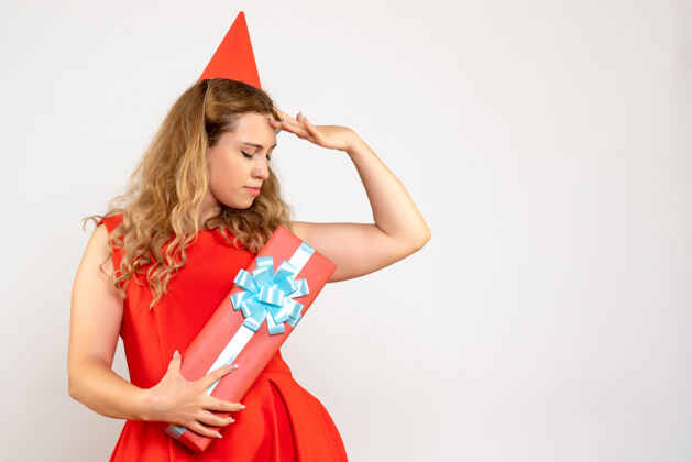 红色正面图身着红色连衣裙的年轻女性用礼物庆祝圣诞节颜色庆祝聚会