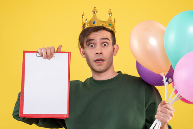 庆祝正面图：戴着皇冠的年轻人拿着黄色的气球惊奇孩子人