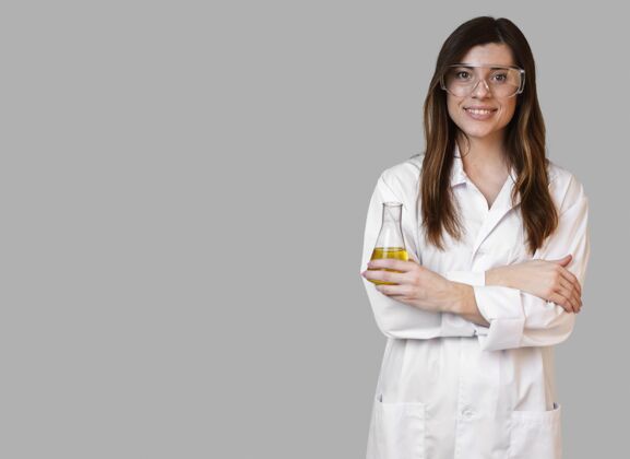科学家女科学家的前视图 戴着安全眼镜 拿着有复印空间的试管实验复制空间研究员