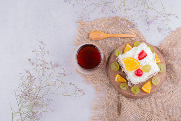 平铺一块正方形的水果蛋糕和一杯茶厨房食宿愉悦