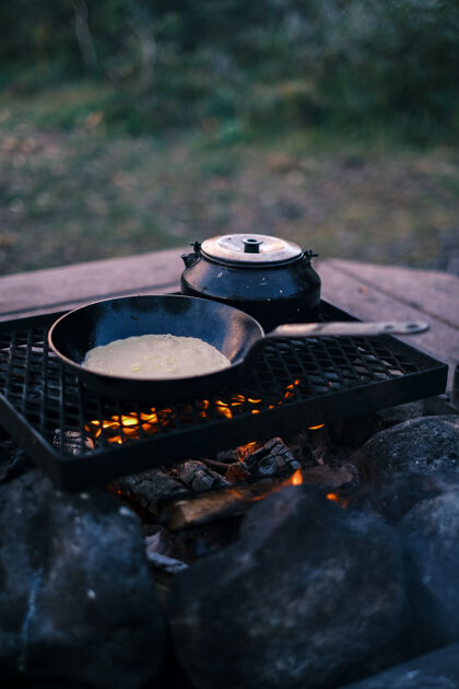 特写烤架上锅和水壶的垂直镜头木头火食物