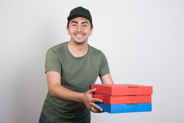 盒子年轻的信使拿着三盒白底披萨拿着披萨微笑