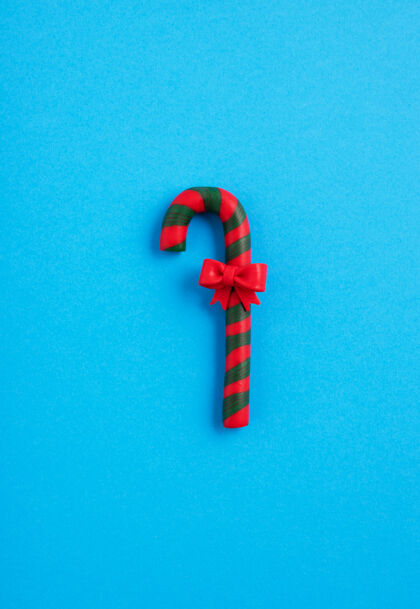 传统绿色和红色糖果藤与一个蓝色的背景 圣诞节的心情鞠躬礼物垂直糖果