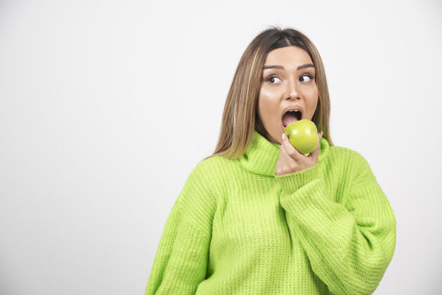 女人穿着绿色t恤的年轻女子正在吃苹果食物吃肖像