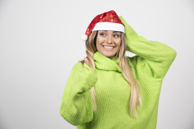 女性戴着圣诞老人红帽子的年轻微笑的女人帽子人类年轻