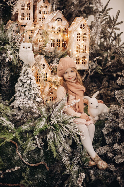 装饰美丽的女孩在一个圣诞装饰与许多树下的雪和灯拍照女儿礼物孩子
