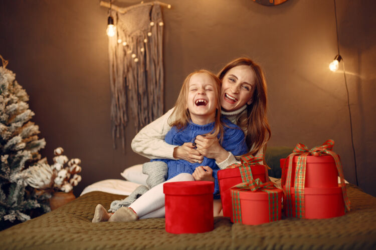蓝色人们在为圣诞节做准备母亲在和女儿玩耍一家人在节日的房间里休息孩子穿着蓝色毛衣爱碗在一起