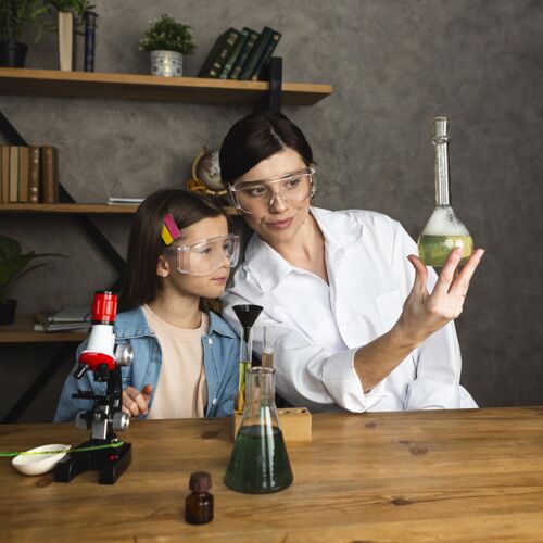 试管女孩和老师用试管和显微镜做科学实验实验创新者化学