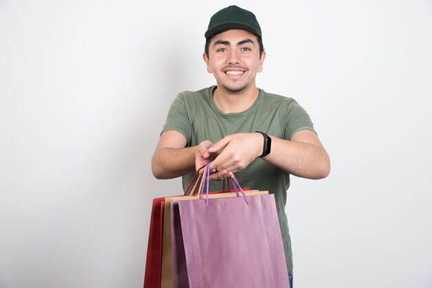 年轻快乐的男人拿着白色背景的购物袋买男人购物