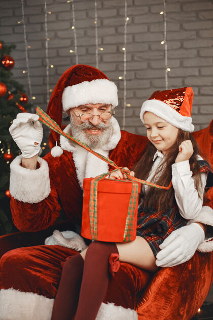 礼物圣诞节 孩子和礼物圣诞老人给孩子带来礼物快乐的小女孩拥抱圣诞老人孩子成人老年