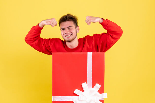 年轻男性正面图穿红衬衫的年轻男子坐在礼品盒内微笑男性衬衫