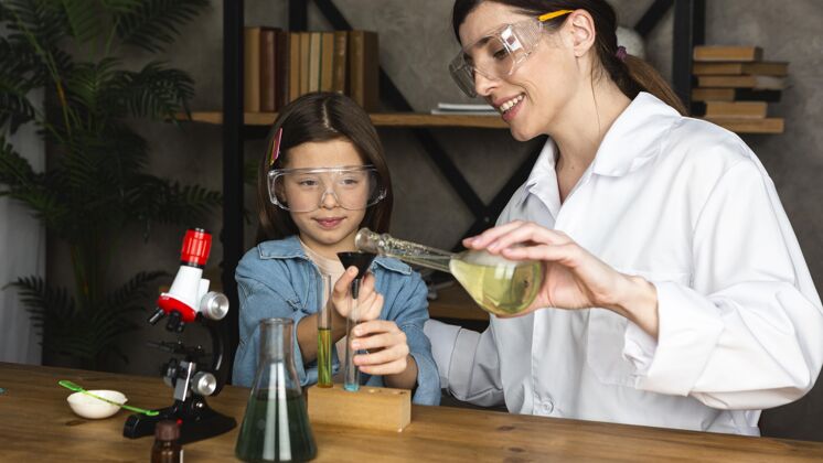 眼镜女孩和老师在做科学实验女人女孩炼金术
