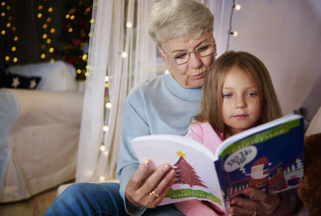 童年奶奶和孙女在床上读故事书卧室祖母拼写