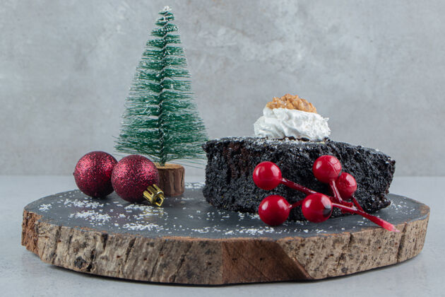 烘焙巧克力蛋糕和圣诞装饰品放在大理石背景的木板上糖果烘焙食品糕点
