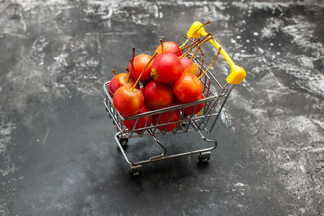 购物迷你购物图的特写镜头 红色樱桃在灰色上购物车健康轮式