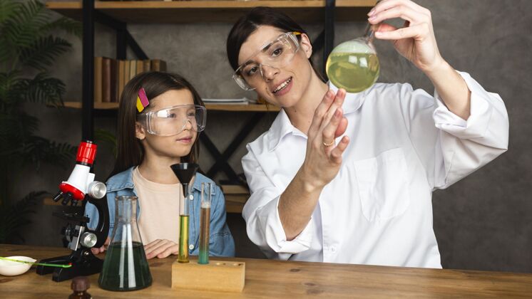 化学家女孩和老师用显微镜做科学实验考试研究员化学