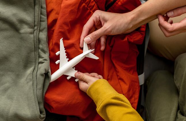 逃脱母子俩把飞机雕像放在行李里的俯视图旅行孩子母亲