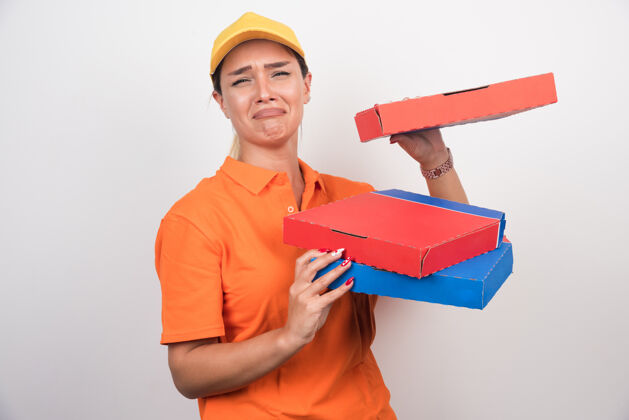 女人带着无聊表情的送货员拿着比萨饼盒站在空白处大笑送货快餐