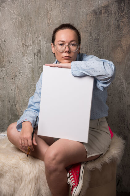 纸坐在空白帆布上 在大理石背景上画笔的女人坐绘画沙发