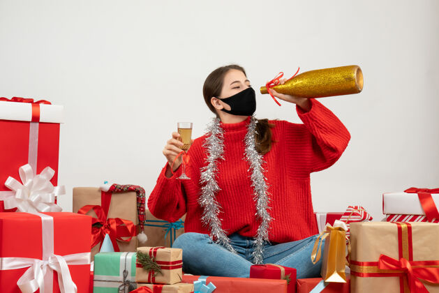 礼物戴着黑色面具的派对女孩拿着香槟围坐在白色的礼物旁黑色礼物举行