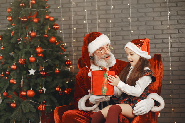圣诞圣诞节 孩子和礼物圣诞老人给孩子带来礼物快乐的小女孩拥抱圣诞老人快乐年轻庆祝